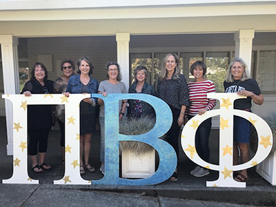 A group of individuals standing outdoors behind Pi Beta Phi letters