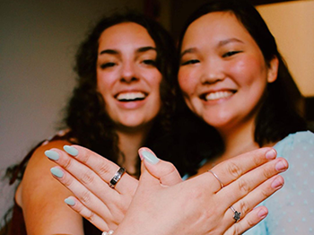 Two individuals making angel wings with their hands